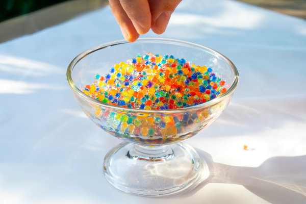 Coloured water beads in glass bowl